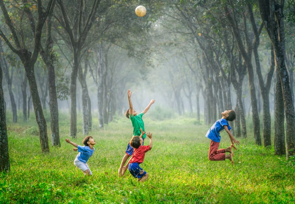 Children leaping for joy in a wood
