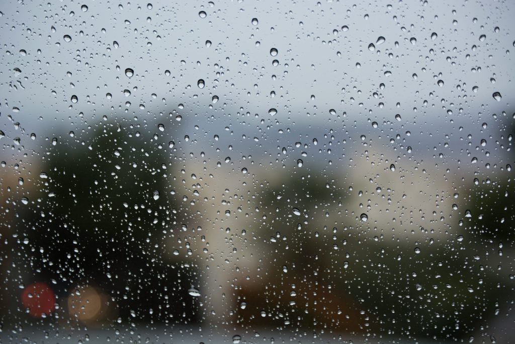 A bleak view through a window covered in raindrops