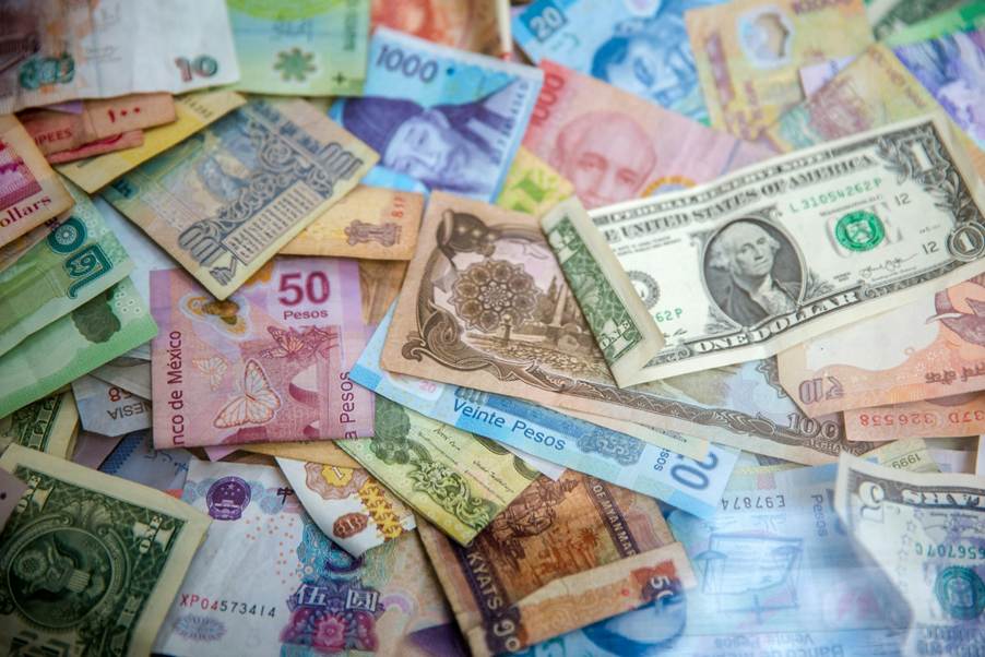 A colourful pile of banknotes of different currencies