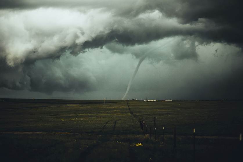 A "twister" joining dark cloud to Earth in the distance