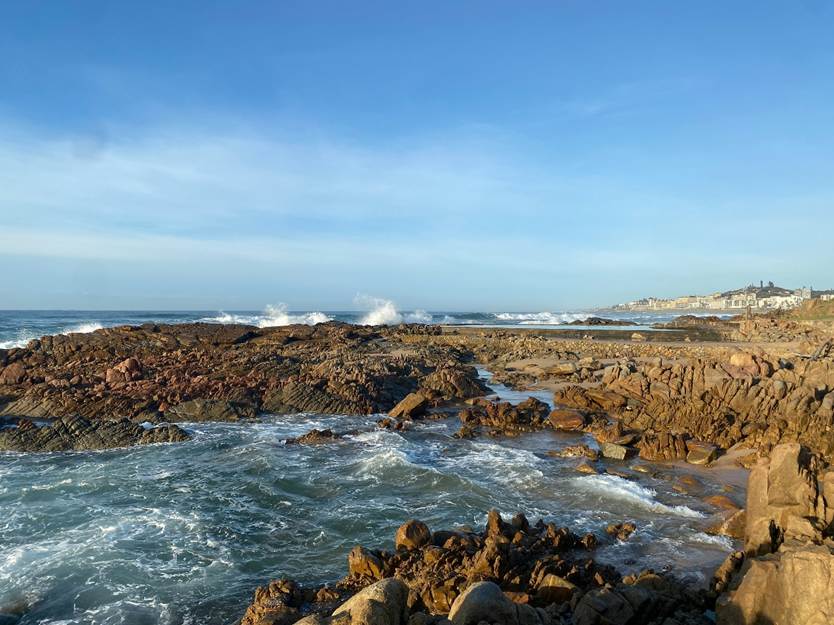 A rocky seashore with a rockpool in the foreground