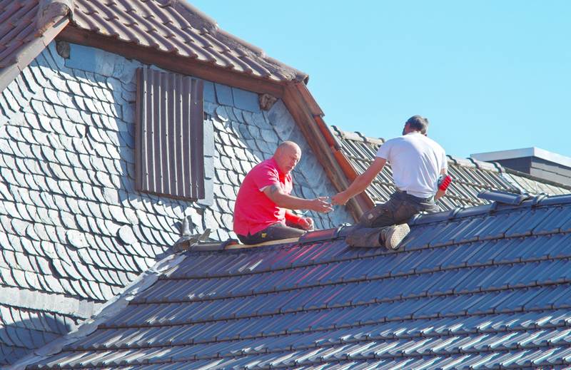 Men repairing the roof of a house