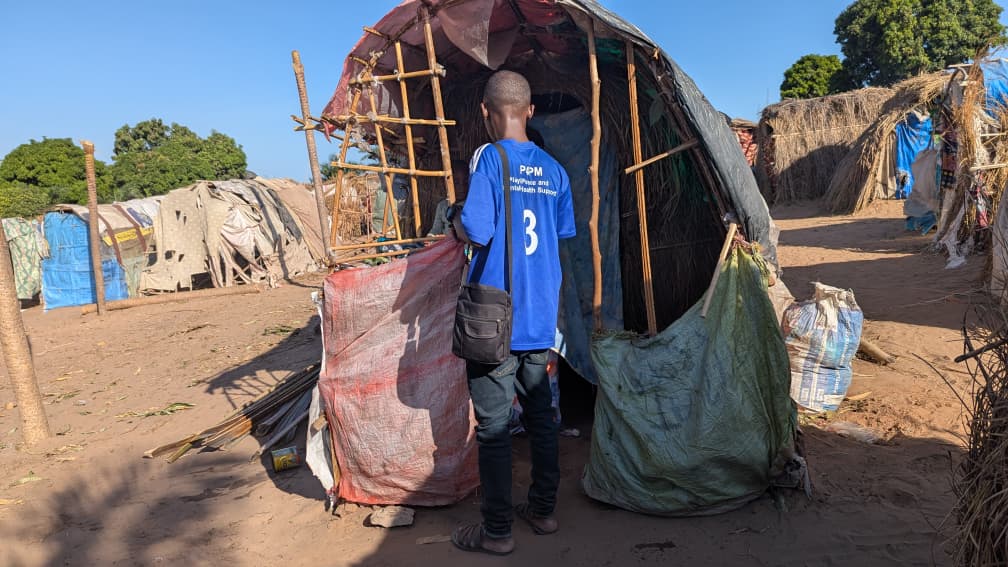 An African standing in a refugee camp appalled at the way people are living