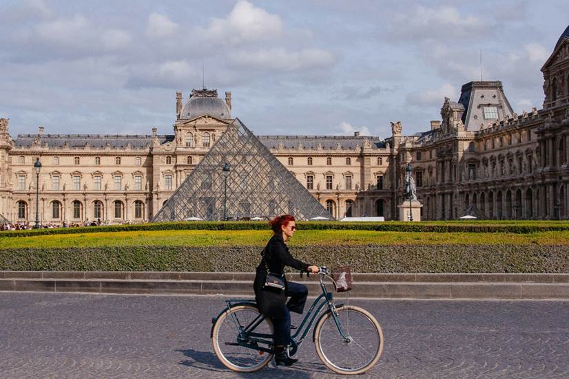 A cyclist passing the Louvre in Paris