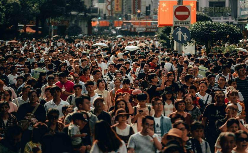 A bust street in a crowded city, full of people
